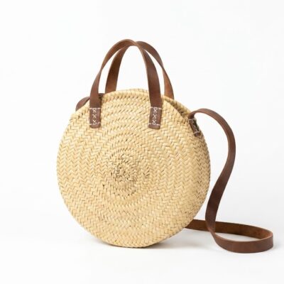 Bolso redondo de hojas de palma y cuero.